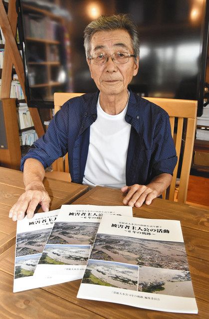 完成した記録誌を手にする染谷修司さん＝常総市で