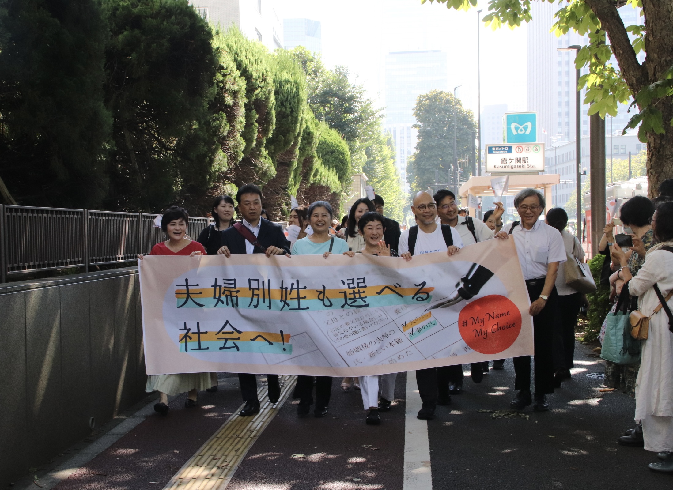 横断幕を掲げて弁護団と原告が入廷行動する様子