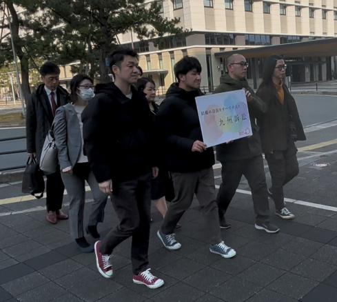 上告のために裁判所に入る原告や弁護団員 原告は結婚の自由をすべての人に九州訴訟と書かれたパネルを持っている。