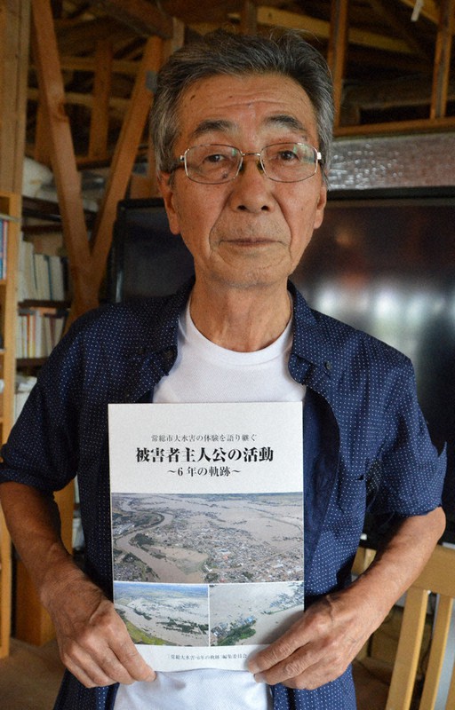 記録誌を手にする染谷修司さん＝茨城県常総市で