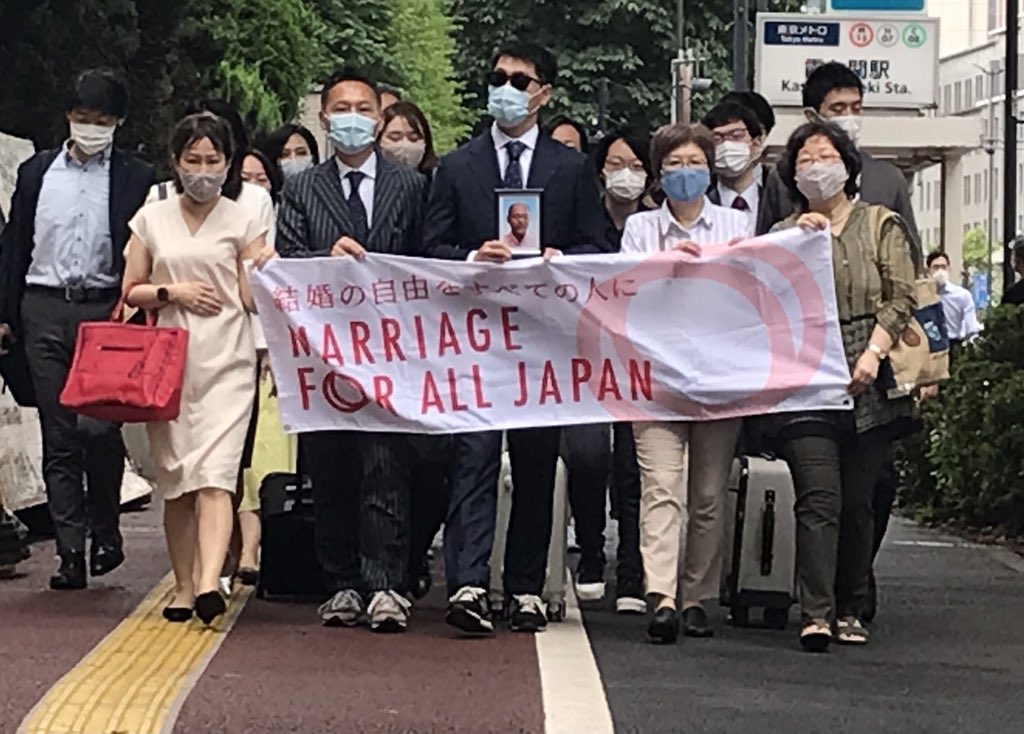 ※写真：東京一次原告の入廷行動の様子。横断幕を持ち東京地方裁判所前を行進。